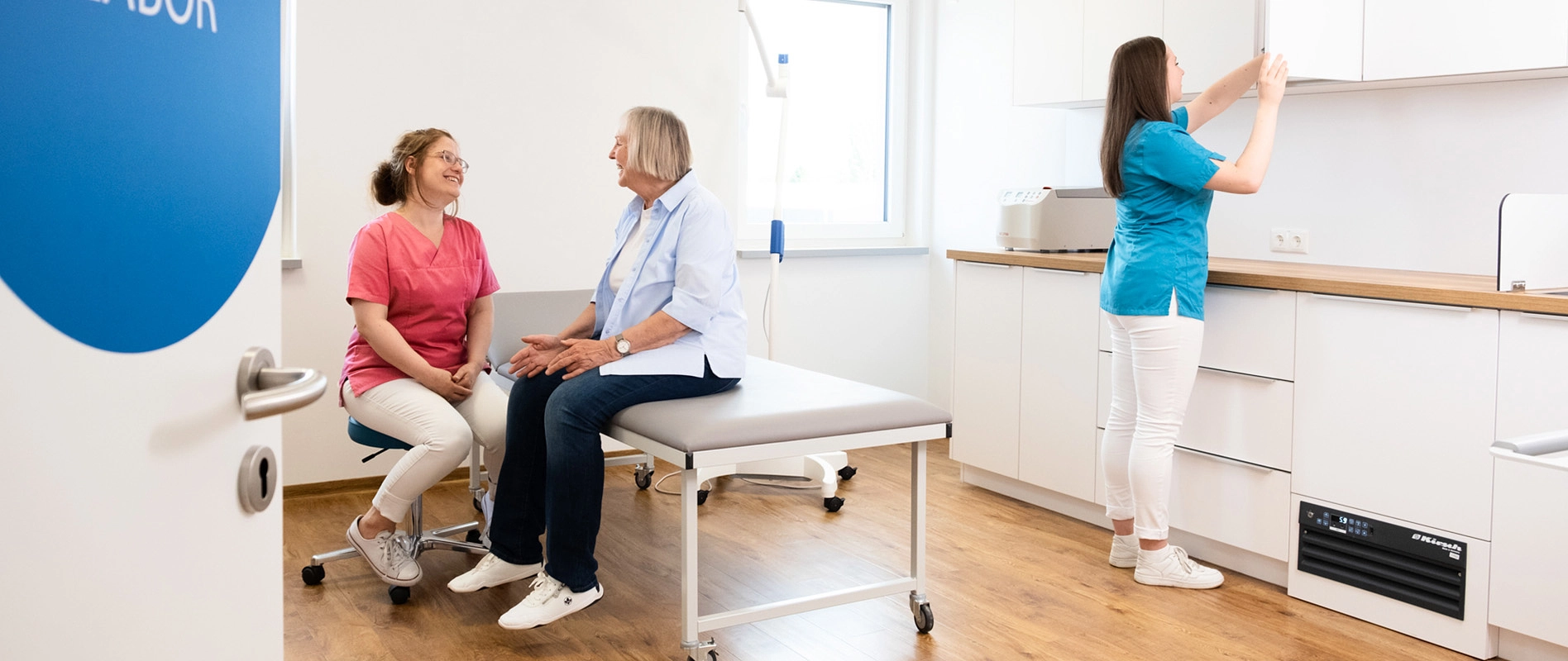 Gespräch zwischen Helferin und Patientin im Behandlungszimmer
