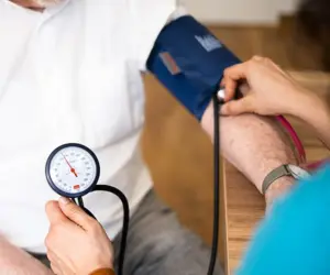 Ärztin misst Blutdruck bei Patient